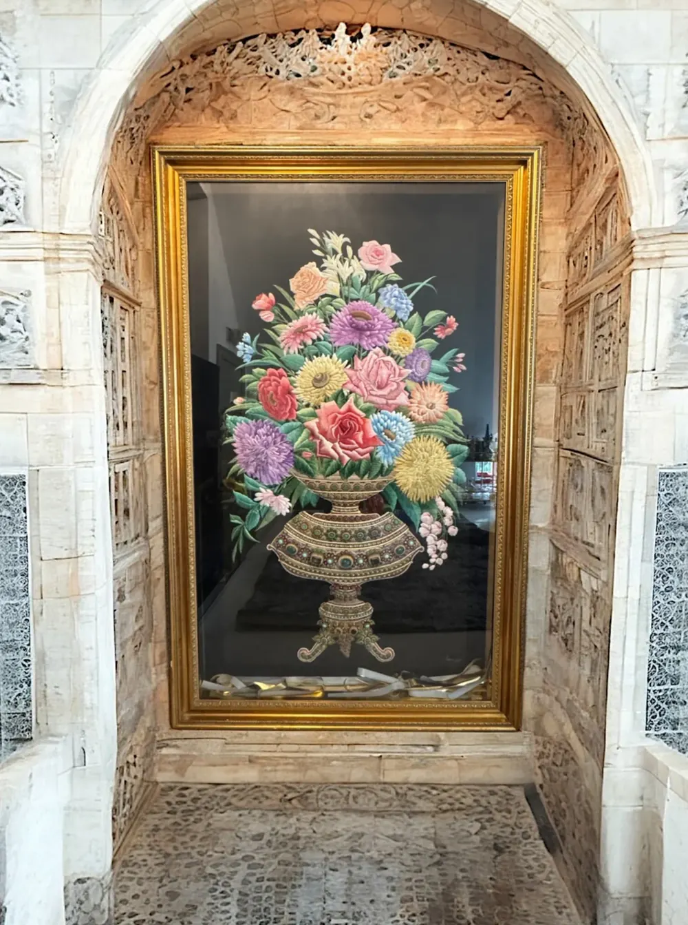 The Vase in its gilded frame within a carved stone niche