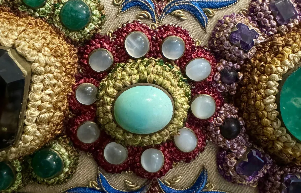 Magnified turquoise rosette ringed with pearls and coloured thread